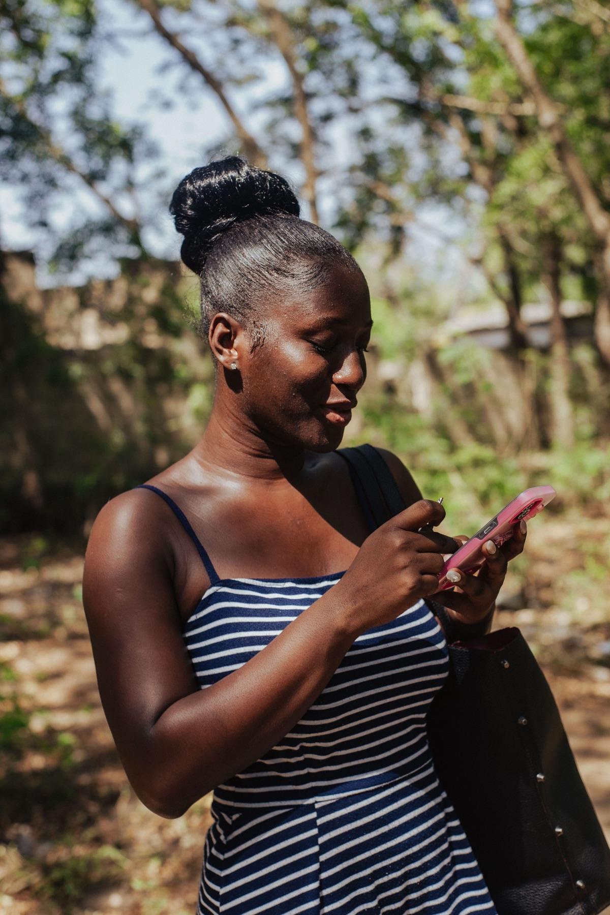 A Baka member checking her phone in Accra